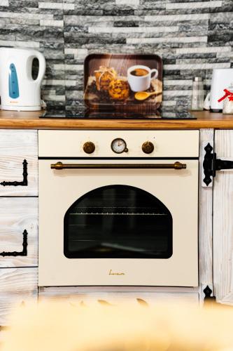 a kitchen with a stove with a cup of coffee at Kata Kulcsosház in Odorheiu Secuiesc