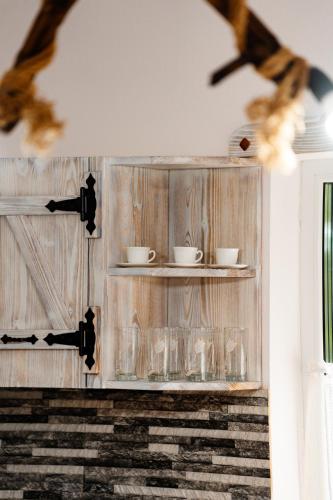 a glass cabinet with plates and cups on it at Kata Kulcsosház in Odorheiu Secuiesc