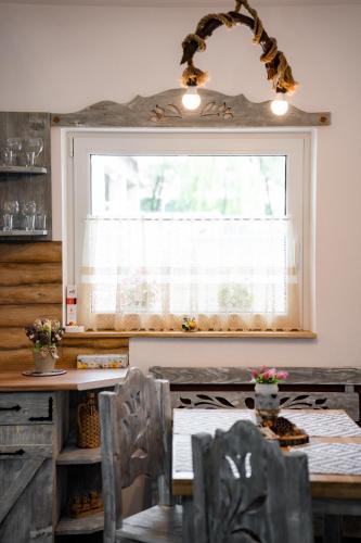 a dining room with a table and a window at Kata Kulcsosház in Odorheiu Secuiesc