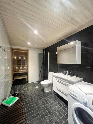 a bathroom with a sink and a toilet at Kotimaailma - Premium 2 bedroom apartment with Terrace & Sauna in Vantaa