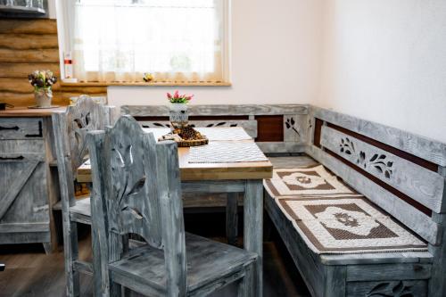 a wooden table and chairs in a room with a window at Kata Kulcsosház in Odorheiu Secuiesc