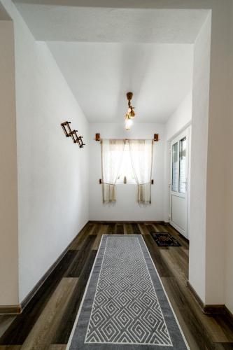 a room with white walls and a rug on the floor at Kata Kulcsosház in Odorheiu Secuiesc
