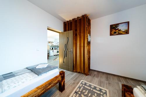 a room with a bed and a door at Kata Kulcsosház in Odorheiu Secuiesc