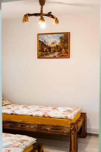 two beds in a room with a painting on the wall at Kata Kulcsosház in Odorheiu Secuiesc