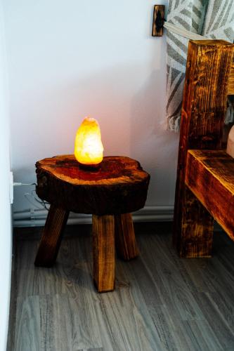 a lamp sitting on a wooden stool in a room at Kata Kulcsosház in Odorheiu Secuiesc