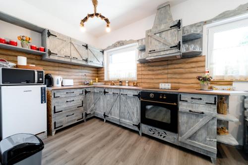 a kitchen with wooden cabinets and a white refrigerator at Kata Kulcsosház in Odorheiu Secuiesc