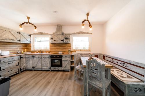 a kitchen with wooden cabinets and a table and chairs at Kata Kulcsosház in Odorheiu Secuiesc