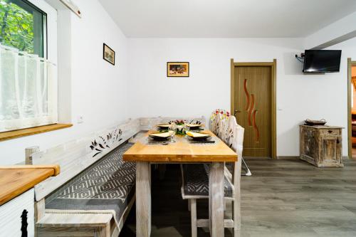 a dining room with a wooden table and chairs at Kata Kulcsosház in Odorheiu Secuiesc