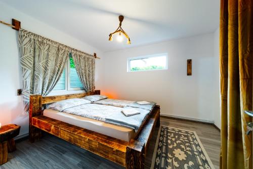 a bedroom with a bed and a window at Kata Kulcsosház in Odorheiu Secuiesc