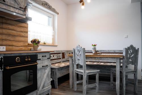 a dining room with a table and chairs and a stove at Kata Kulcsosház in Odorheiu Secuiesc