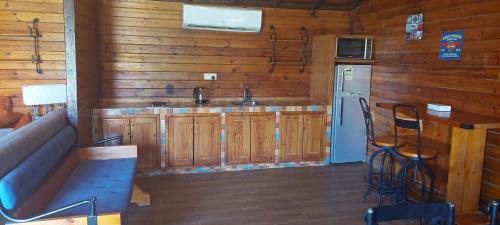 a kitchen with wooden cabinets and a refrigerator and a sink at Tola Holiday House Al Rimal in Riyadh
