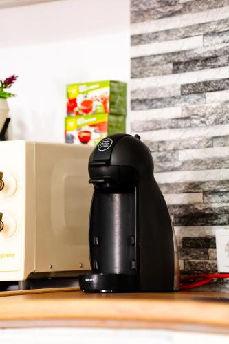 a black coffee maker sitting on a counter at Kata Kulcsosház in Odorheiu Secuiesc