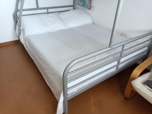 a bedroom with a bunk bed with white sheets at CASA ADRIANO frontemare WIFI e NETFLIX in Lido Adriano