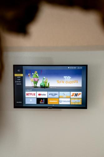 a flat screen tv with two frog cartoons on it at Kata Kulcsosház in Odorheiu Secuiesc