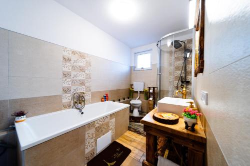 a bathroom with a sink and a tub and a toilet at Kata Kulcsosház in Odorheiu Secuiesc
