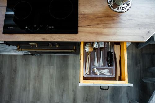 a drawer in a wooden cabinet with utensils at Kata Kulcsosház in Odorheiu Secuiesc