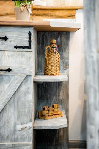 a wooden shelf with a basket and teddy bears on it at Kata Kulcsosház in Odorheiu Secuiesc