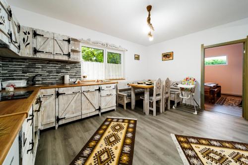 a kitchen with a table and a dining room at Kata Kulcsosház in Odorheiu Secuiesc