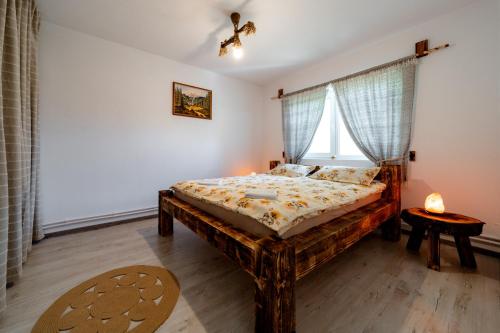 a bedroom with a wooden bed and a window at Kata Kulcsosház in Odorheiu Secuiesc