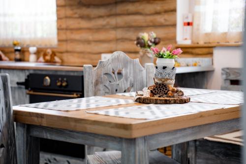 a table with a vase of flowers on top of it at Kata Kulcsosház in Odorheiu Secuiesc