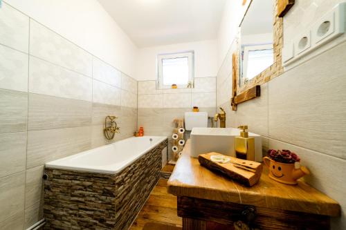 a bathroom with a bath tub and a sink at Kata Kulcsosház in Odorheiu Secuiesc