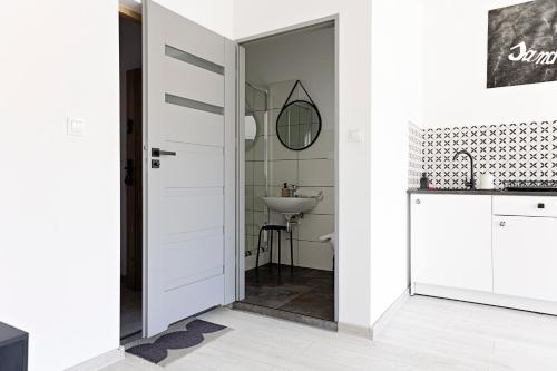 Un baño con una puerta que da a un lavabo. en Apartamenty Folk Deluxe, en Lublin
