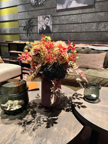 a vase filled with flowers sitting on a table at Cosmopolite Hotel Nieuwpoort-Bad in Nieuwpoort
