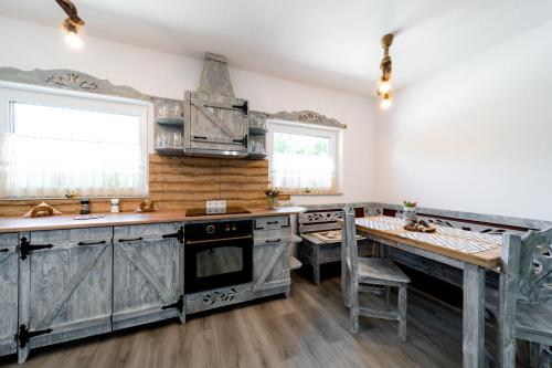 a kitchen with gray cabinets and a wooden floor at Kata Kulcsosház in Odorheiu Secuiesc