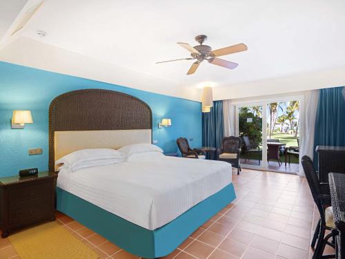 a bedroom with a bed with a blue wall at Barceló Bávaro Beach - Adults Only All Inclusive in Punta Cana