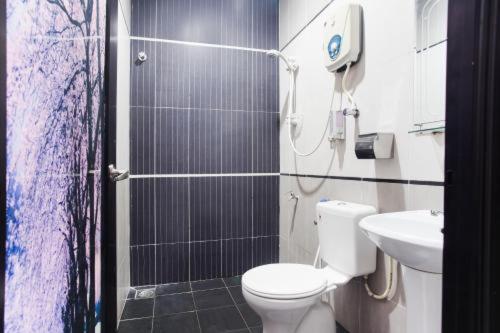 uma casa de banho com um chuveiro, um WC e um lavatório. em Sejati Hotel em Sitiawan