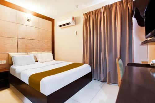 a hotel room with a bed and a television at Sejati Hotel in Sitiawan