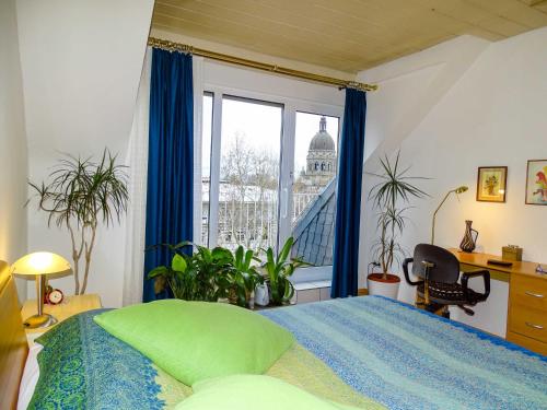 a bedroom with a bed and a large window at City-Dachapartment Mainz in Mainz