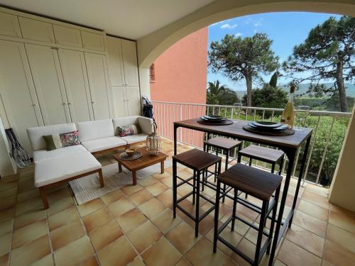 a patio with a couch and a table and chairs at Studio Apartment - Domaine du Golf Resort in Roquebrune-sur-Argens