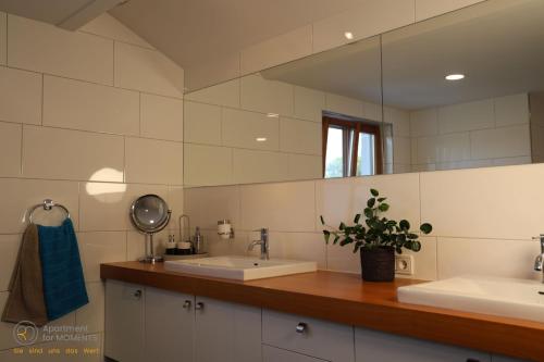 a bathroom with two sinks and a mirror at RM Apartment for Moments in Dornbirn