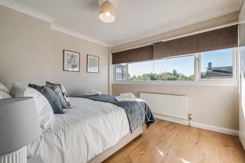 um quarto com uma cama e uma grande janela em Stunning and Modern House - Perfect for Families em Bedford