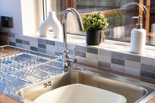 um lavatório numa cozinha ao lado de uma janela em Stunning and Modern House - Perfect for Families em Bedford