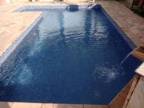 ein blauer Pool mit einem Springbrunnen in der Unterkunft Hospedagem Em Santana de Parnaíba in Santana de Parnaíba