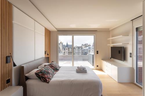 Un dormitorio con una cama y una ventana grande. en Cap de Jade - Jolie vue sur plage de Rochebonne, en Saint-Malo
