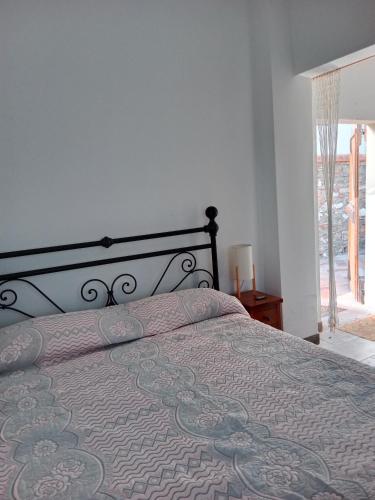 ein Schlafzimmer mit einem Bett mit einer Bettdecke und einem Fenster in der Unterkunft Casa Gaia in San Giuliano Terme