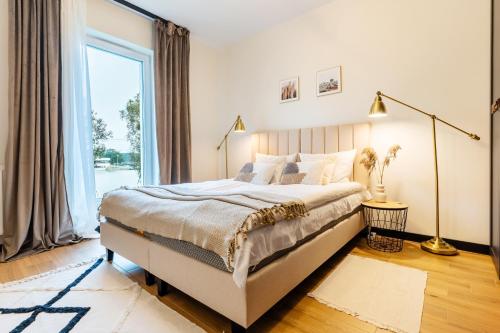 sypialnia z dużym łóżkiem i dużym oknem w obiekcie Marina Relax w Iławie