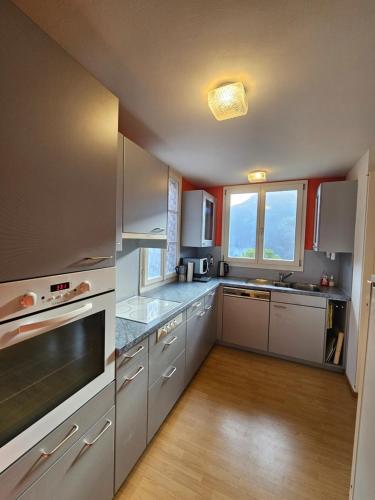 eine große Küche mit weißen Geräten und Holzböden in der Unterkunft Chalet Aargovia South in Wengen