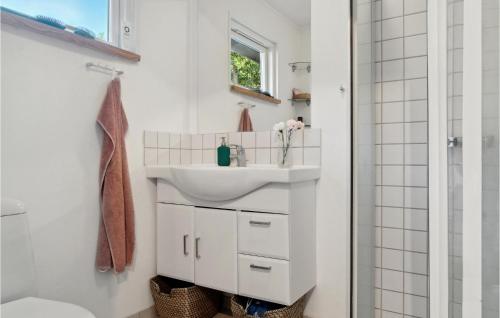 y baño blanco con lavabo y ducha. en Beautiful Home In Holbk With Kitchen en Holbæk