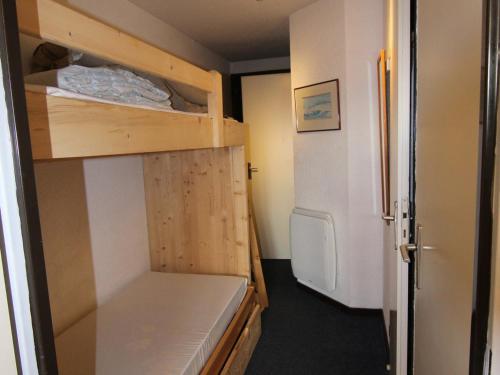 ラルプ・デュエズにあるAppartement Huez, 2 pièces, 4 personnes - FR-1-405-138のベッド1台、冷蔵庫が備わる小さな客室です。