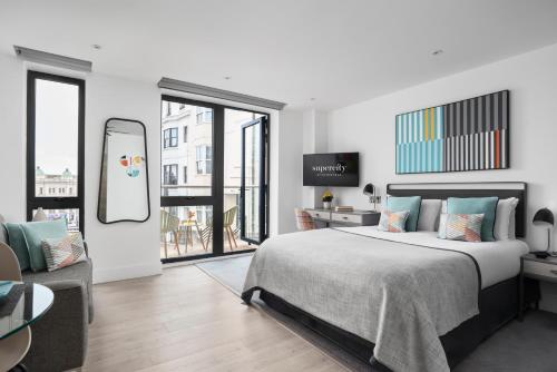 - une chambre avec un lit, une table et un miroir dans l'établissement Q Square by Supercity Aparthotels, à Brighton et Hove