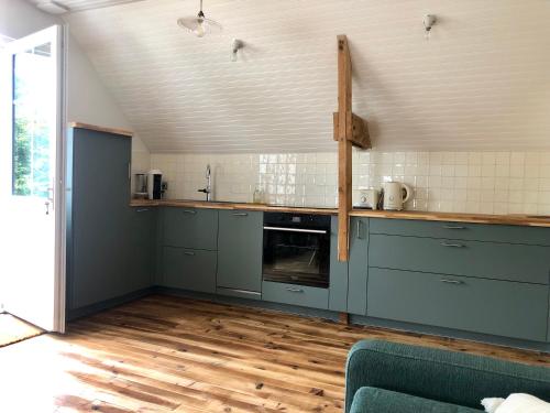 Il comprend une cuisine avec des placards bleus et du parquet. dans l'établissement Gite du Verger de Kerduel, à Moëlan-sur-Mer