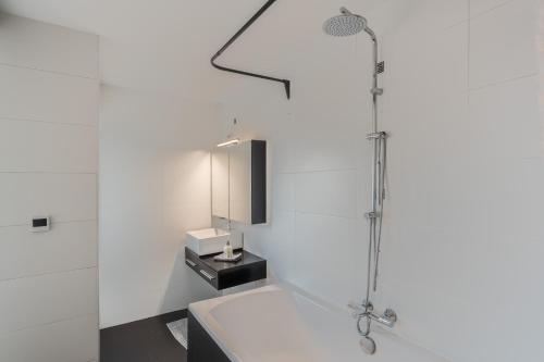 a white bathroom with a shower and a sink at Cosy & Spacious House in Center in Kortrijk