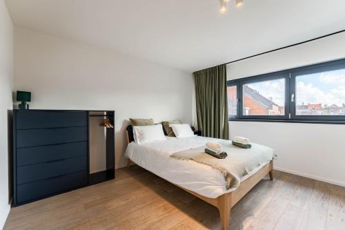 a bedroom with a bed and a large window at Cosy & Spacious House in Center in Kortrijk