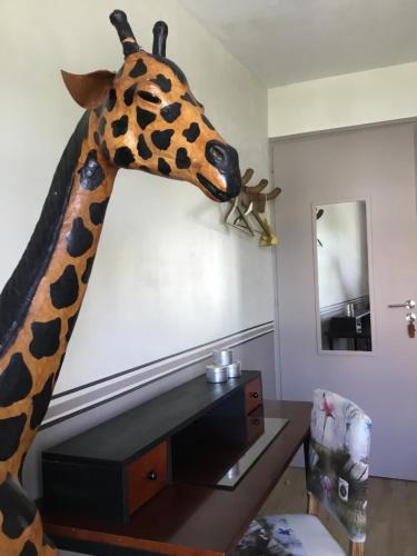 a giraffe head hanging on a wall in a room at BnB Montacutain in Montaigu-Vendée