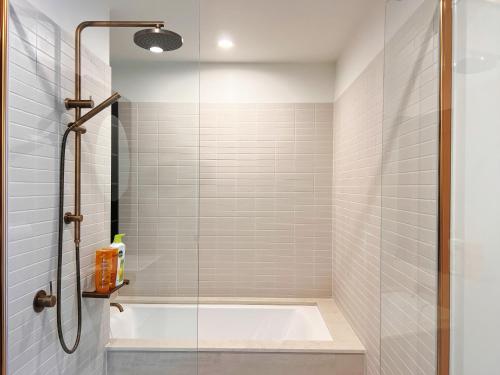 a bathroom with a shower with a bath tub at Melbourne CBD 2B2B1S with City & Sea Views in Melbourne