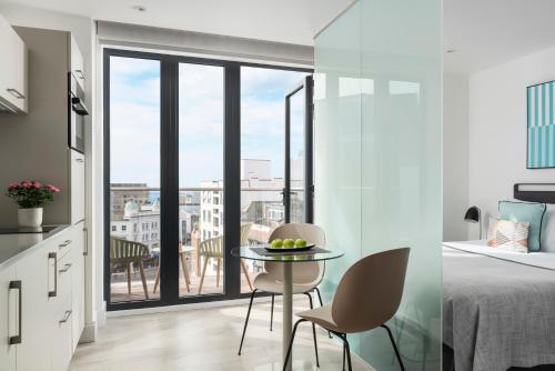 - une chambre avec un lit, une table et des chaises dans l'établissement Q Square by Supercity Aparthotels, à Brighton et Hove